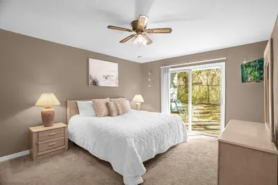 a bedroom with a bed and a ceiling fan at Ground Level Condo with Garden Patio in Kissimmee