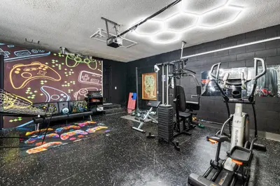 a room with a gym with a wall covered in graffiti at Beautiful 5BR 4 baths Themed home near Disney and Universal, Private Pool, Gameroom, baby Crib and more in Kissimmee
