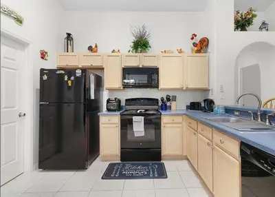 a kitchen with a black refrigerator and a sink at Tropical Escape by Shine Villas 244 villa in Kissimmee