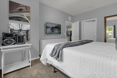 a bedroom with a white bed and a picture of the eiffel tower at 3 Bedrooms 2 Bathrooms Lucaya Village 13-107 in Kissimmee
