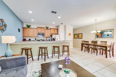 a living room and kitchen with a couch and a table at Resort Perks and Private Pool Kissimmee Retreat! in Kissimmee