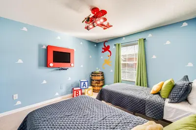 a bedroom with two beds and a tv on the wall at Resort Perks and Private Pool Kissimmee Retreat! in Kissimmee