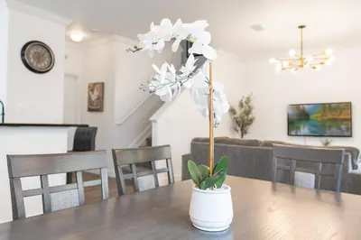 a white flower in a white vase on a table at Cozy 4Bedrooms At Lucaya- 7 miles from Disney in Kissimmee