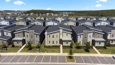 an aerial view of a row of houses at New Home 9 Bedrooms and 5 Bath At Storey Lake in Kissimmee