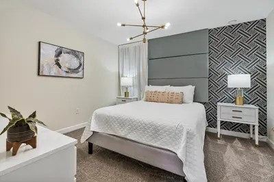 a bedroom with a bed and a accent wall at New Home 9 Bedrooms and 5 Bath At Storey Lake in Kissimmee