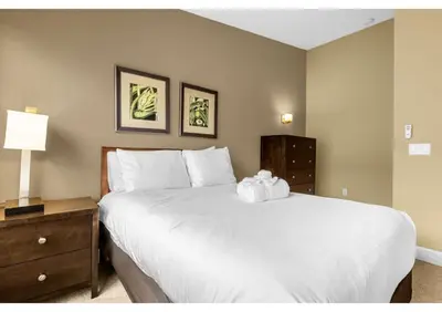 a bedroom with a large white bed and a nightstand at Your Summer Getaway Awaits - Townhome by Disney! in Orlando