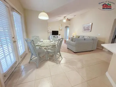a dining room and living room with a table and chairs at 35 - Relax & Play 4-Bed Villa with Pool & Game Room Minutes to Disney in Orlando
