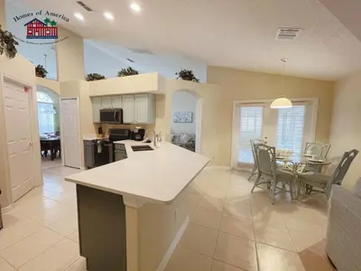 a kitchen and living room with a table and chairs at 35 - Relax & Play 4-Bed Villa with Pool & Game Room Minutes to Disney in Orlando