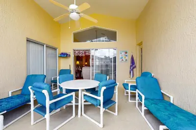 a waiting room with a table and blue chairs at Disney 15 Min - Sleeps 8 - Private Pool in Kissimmee