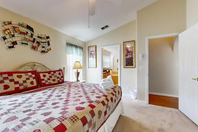 a bedroom with a bed with a colorful bedspread at Disney 15 Min - Sleeps 8 - Private Pool in Kissimmee