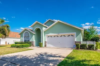 a green house with a white garage at The Oasis in Orlando