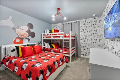 a bedroom with a bed with a mickey mouse bedspread at New Home 4 Bedrooms 3 Bathrooms At Storey Lake in Kissimmee