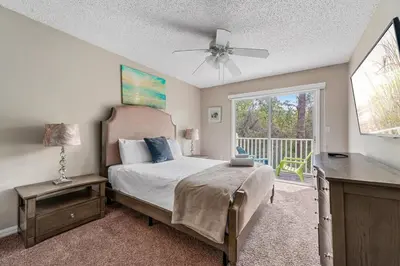 a bedroom with a bed with a ceiling fan and a window at Near Disney + FREE Clubhouse + Pool + GYM + Sauna in Kissimmee