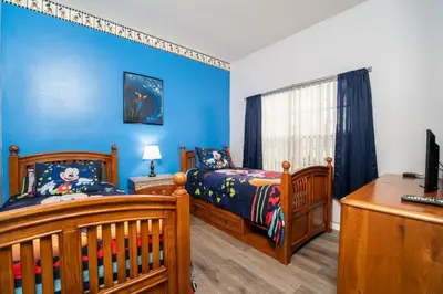 a blue bedroom with a bed and a crib at Sweet Memories in Kissimmee
