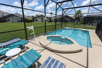 a swimming pool with blue lounge chairs and a swimming pool at Sweet Memories in Kissimmee