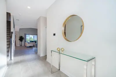 a hallway with a glass table and a mirror at 800MO VILLA 5 BED/5 BA in Orlando