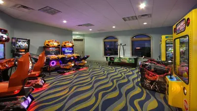 a gaming room with arcade games and video games at 800MO VILLA 5 BED/5 BA in Orlando