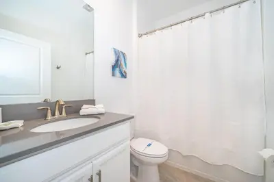 a white bathroom with a sink and a toilet at 3000EB VILLA 5 BED/5 BA in Kissimmee