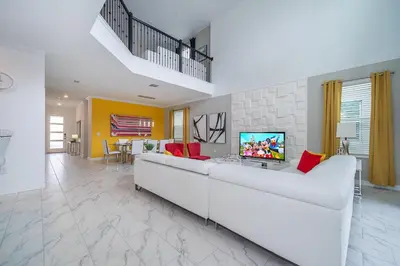 a living room with a white couch and a tv at 4156DS VILLA 5 BED/5 BA in Kissimmee