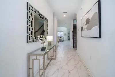 a hallway with a table and a mirror on a wall at 4156DS VILLA 5 BED/5 BA in Kissimmee