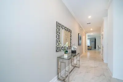 a hallway of a home with white walls and tile floors at 4176SS STOREY LAKE VILLA WITH PRIVATE POOL in Kissimmee