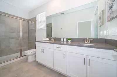 a bathroom with a toilet and a sink and a shower at 4338JC VILLA 5 BED/5 BA (SANITIZED) in Kissimmee