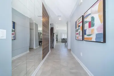 a hallway with paintings on the walls of a house at 4338JC VILLA 5 BED/5 BA (SANITIZED) in Kissimmee