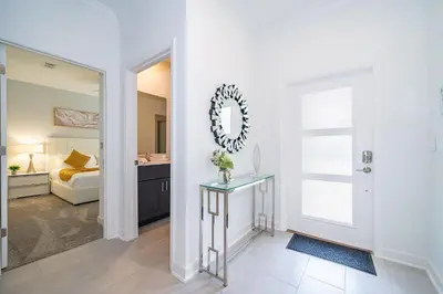 a bathroom with a mirror and a bedroom with a bed at 2472PB TOWNHOUSE 4 BEDROOMS & 3 BATHROOMS + POOL in Kissimmee