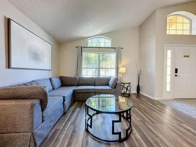 a living room with a couch and a glass table at 5 Star Home Private Pool & JaccuzziFree Wi-Fi villa in Kissimmee