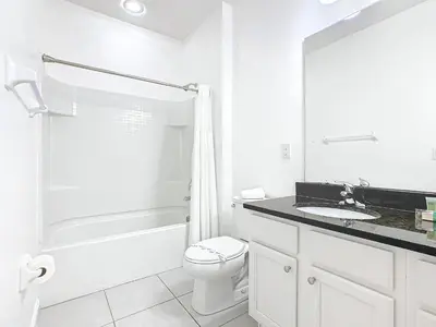 a white bathroom with a toilet and a sink at Elegant Villa 12BD-12BA Vacation Haven BV368 in Kissimmee