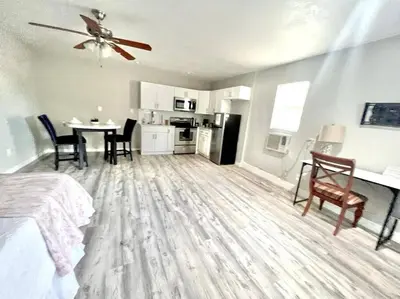 a room with a bed and a table and a kitchen at Quiet home in Metrowest in Orlando
