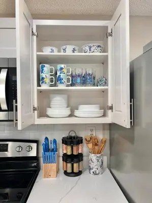 a kitchen cabinet with plates and utensils in it at Quiet home in Metrowest in Orlando