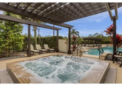 a hot tub on a patio next to a swimming pool at Summer Deal - Relax & Unwind, Townhome by Disney! in Orlando
