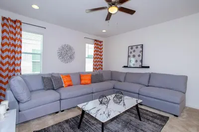 a living room with a blue couch and a ceiling fan at Gorgeous Family Home! Sleeps 28 BLV103 in Kissimmee
