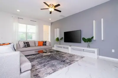 a living room with a couch and a flat screen tv at Gorgeous Family Home! Sleeps 28 BLV103 in Kissimmee