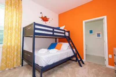 a bunk bed in a room with an orange wall at Gorgeous Family Home! Sleeps 28 BLV103 in Kissimmee
