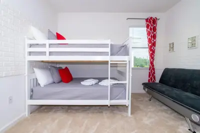 a white bunk bed in a room with a couch at Gorgeous Family Home! Sleeps 28 BLV103 in Kissimmee