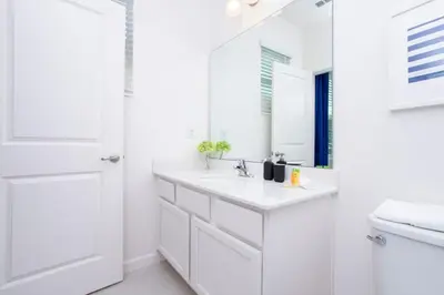 a white bathroom with a sink and a mirror at Gorgeous Family Home! Sleeps 28 BLV103 in Kissimmee