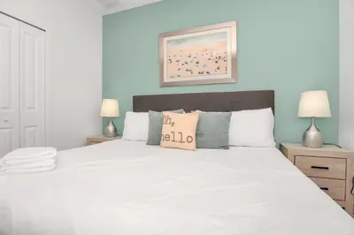 a bedroom with a large white bed with two lamps at Vacation Paradise Home, Private Pool, Game Room BL102 in Kissimmee