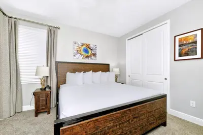 a bedroom with a large bed with white sheets at Astounding Home Near Disney With Themed & Media Room, Pool Table With Waterpark & Resort Access At Encore Resorts Reunion - 240Cl in Kissimmee