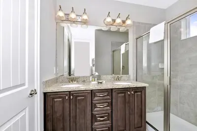a bathroom with two sinks and a shower at Astounding Home Near Disney With Themed & Media Room, Pool Table With Waterpark & Resort Access At Encore Resorts Reunion - 240Cl in Kissimmee