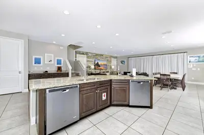 a kitchen with a counter and a dining room at Astounding Home Near Disney With Themed & Media Room, Pool Table With Waterpark & Resort Access At Encore Resorts Reunion - 240Cl in Kissimmee