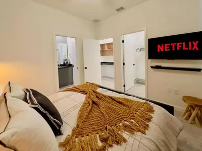 a bedroom with a bed with anetflix sign on the wall at Modern 3BR3BA Home at The Hub Reserve in Kissimmee