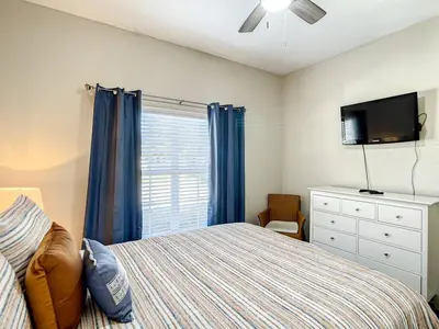 a bedroom with a bed and a tv and a window at Paradise Palms Resort Townhome Close to Disney in Kissimmee