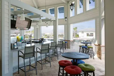 a patio with tables and chairs and a bar at StoreyLake Disney Pool Home, Lake View, By Disney in Kissimmee