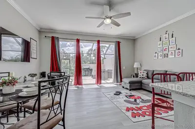 a living room with a table and red curtains at SilverPalm Disney Home, Free Amenities, 3mi Disney in Kissimmee