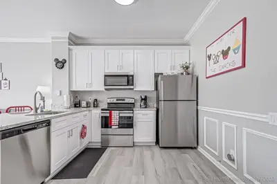 a kitchen with white cabinets and a stainless steel refrigerator at SilverPalm Disney Home, Free Amenities, 3mi Disney in Kissimmee
