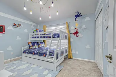 a childs bedroom with a white bunk bed and blue walls at SilverPalm Disney Home, Free Amenities, 3mi Disney in Kissimmee