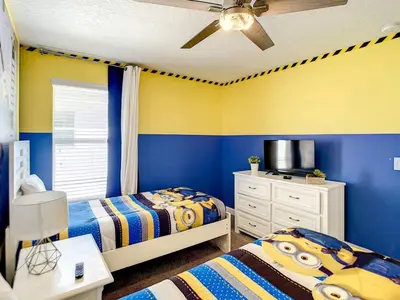 two beds in a bedroom with blue and yellow walls at StoreyLake Imagination Villa, 5mi Disney Universal in Kissimmee