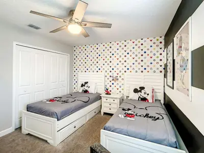 a bedroom with two beds and a ceiling fan at StoreyLake Imagination Villa, 5mi Disney Universal in Kissimmee
